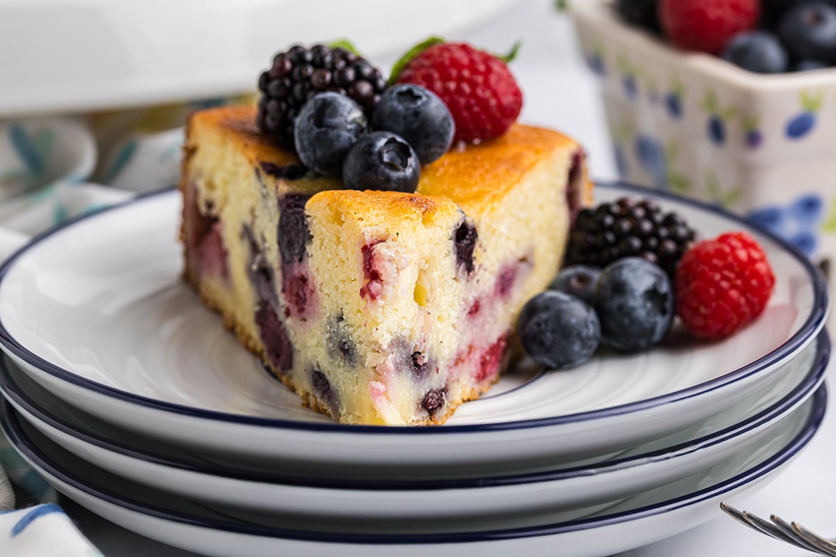 straight on shot of slice of berry ricotta cheesecake on plate