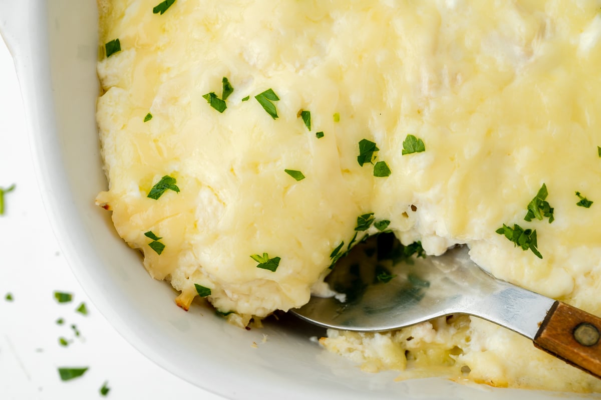 close up overhead shot of serving spoon in chicken alfredo bake