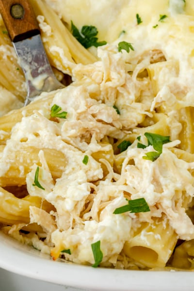 close up overhead shot of chicken Alfredo bake with serving spoon in it