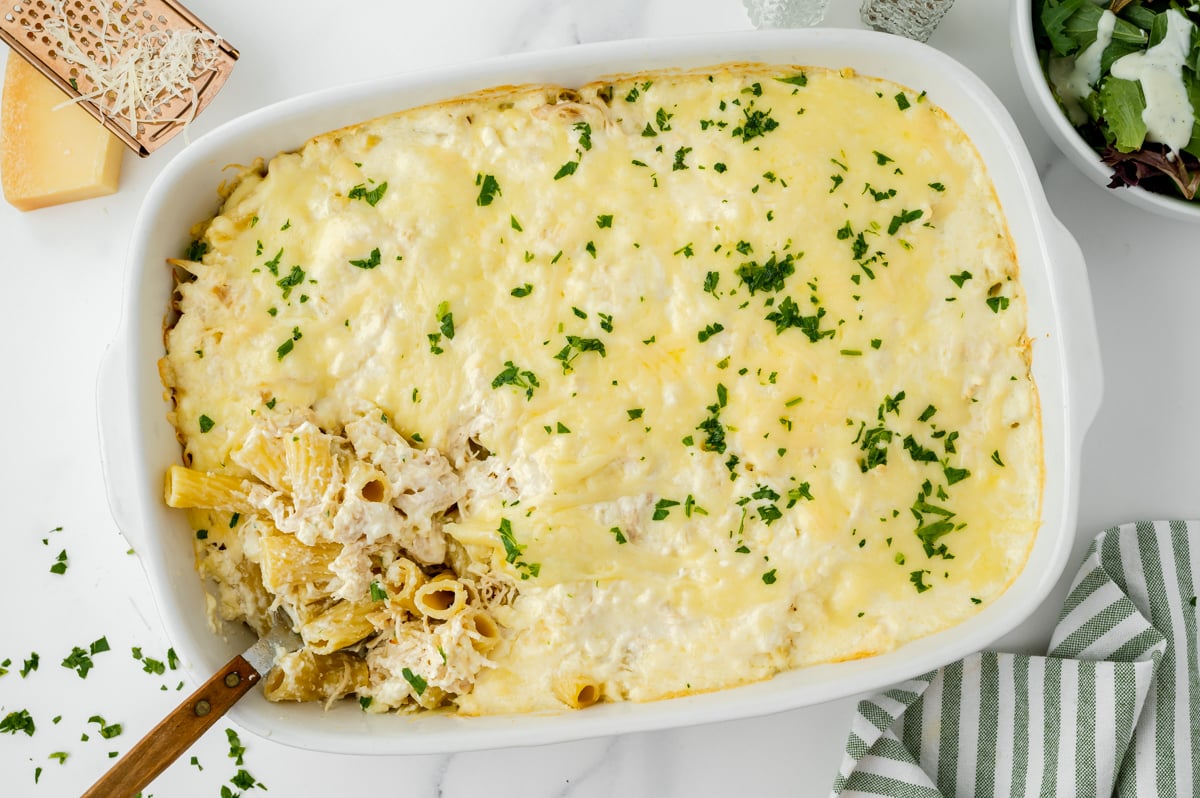 overhead shot of chicken Alfredo bake with serving spoon in it