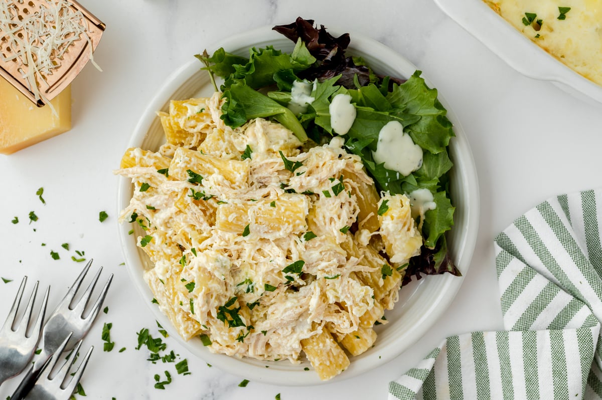 overhead shot of plate of chicken alfredo bake with salad