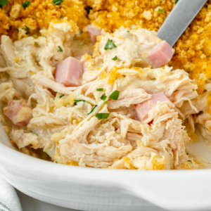 close up angled shot of serving spoon scooping up chicken cordon bleu casserole