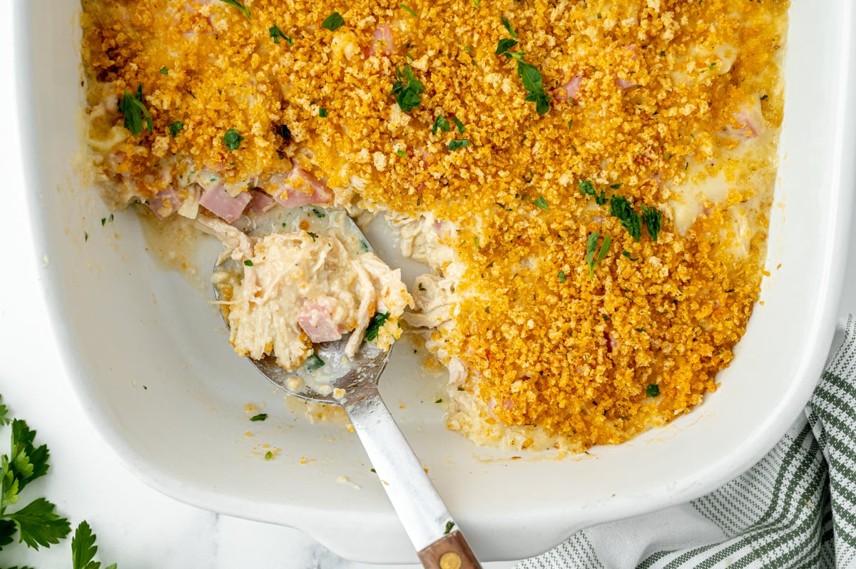 overhead shot of serving spoon in casserole dish with chicken casserole