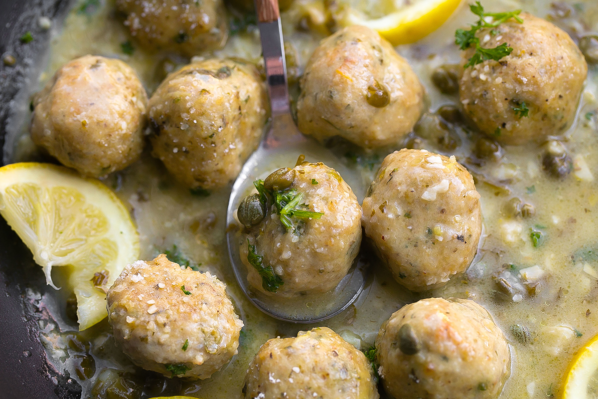 spoon in pan of chicken piccata meatballs