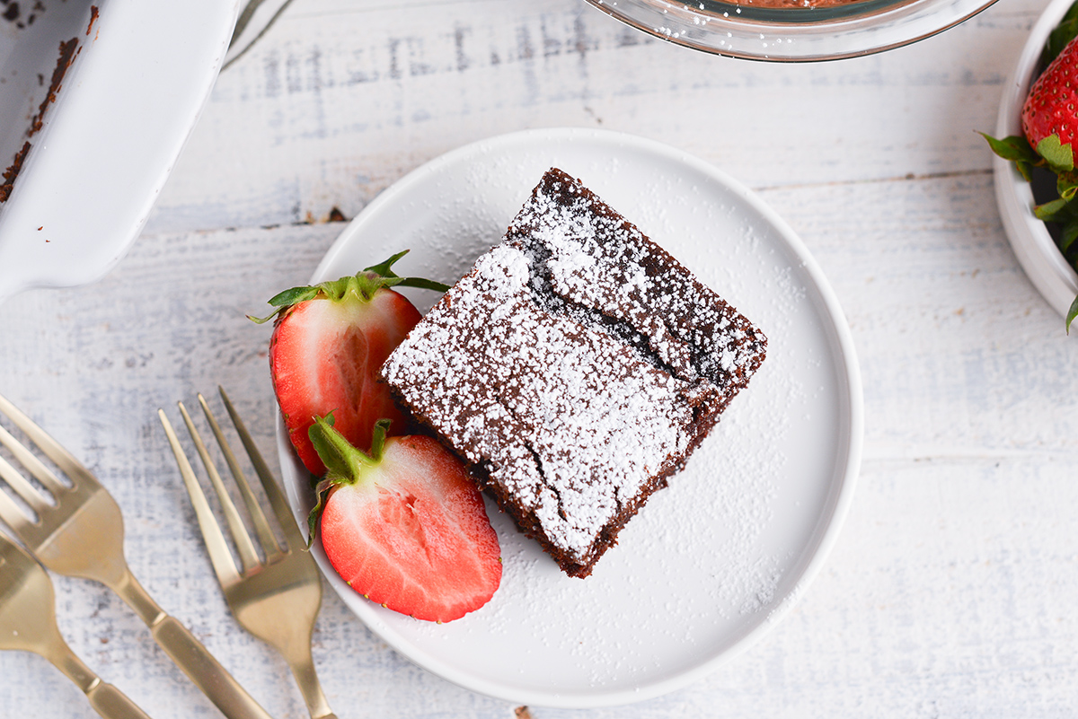 overhead shot of slice of chocolate cake on plate with strawberries