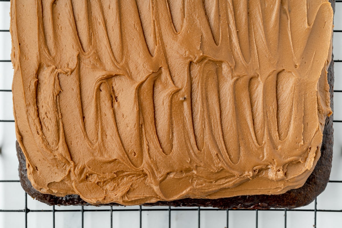 close up overhead shot of chocolate buttercream frosting recipe spread onto cake
