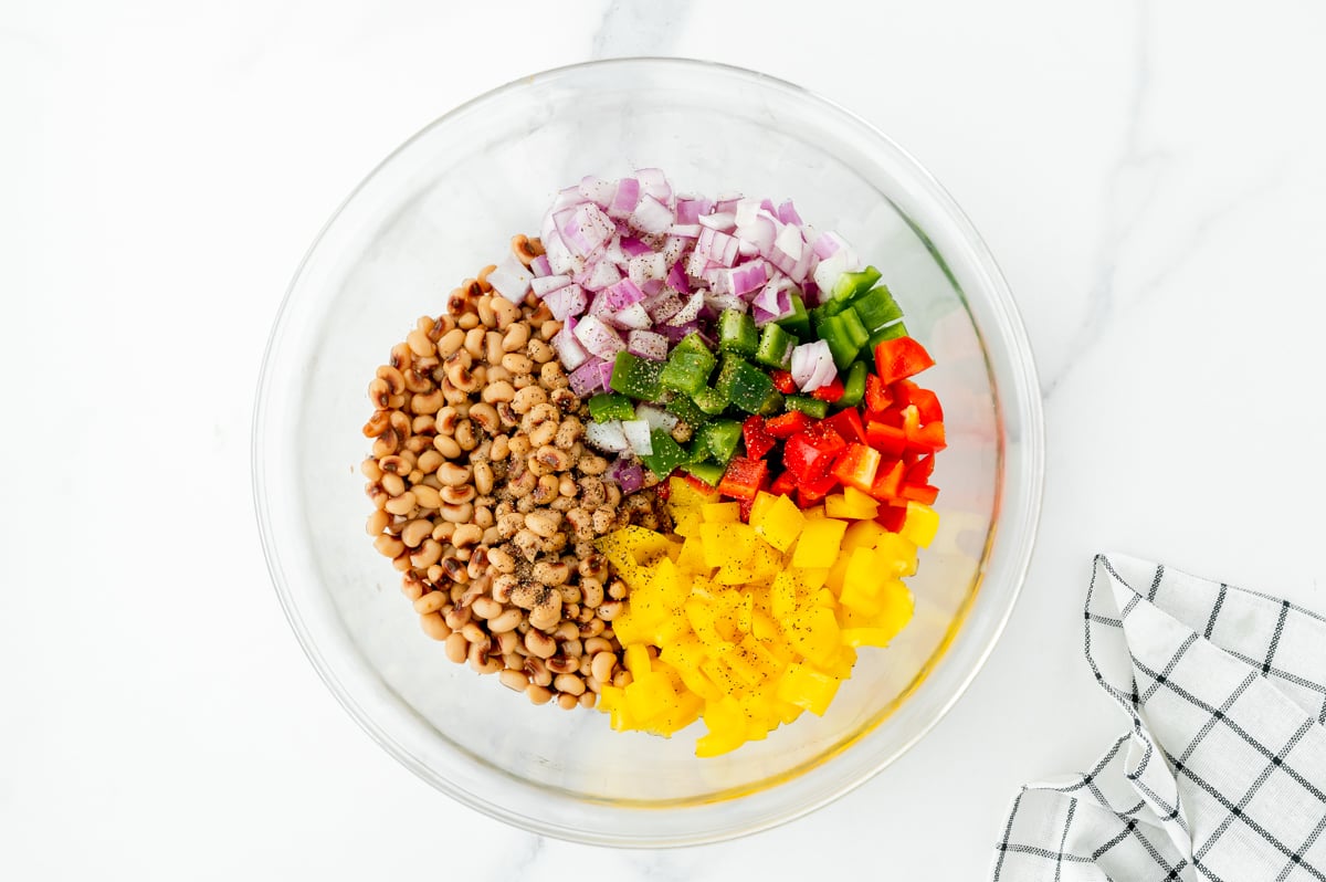 chopped veggies and black eyed peas in bowl- ingredients for corn bread salad recipe