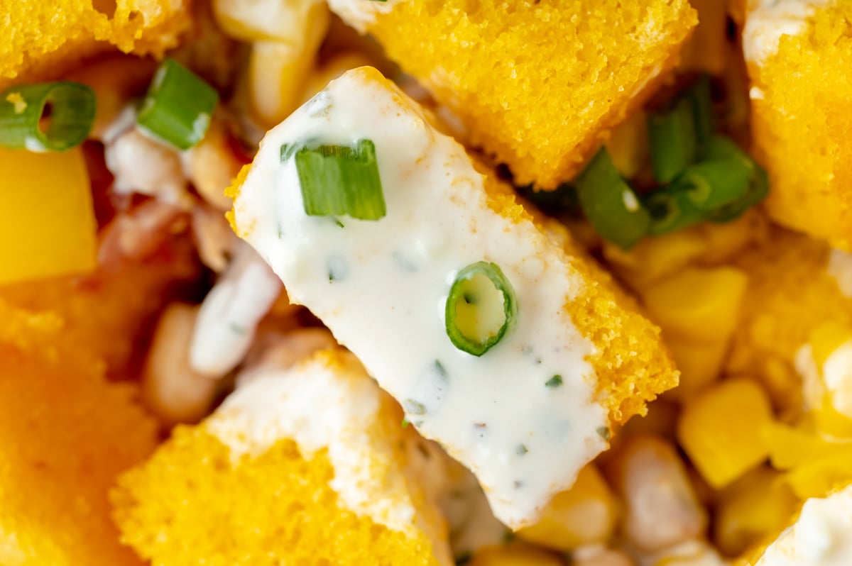 close up of cornbread cube topped with dressing