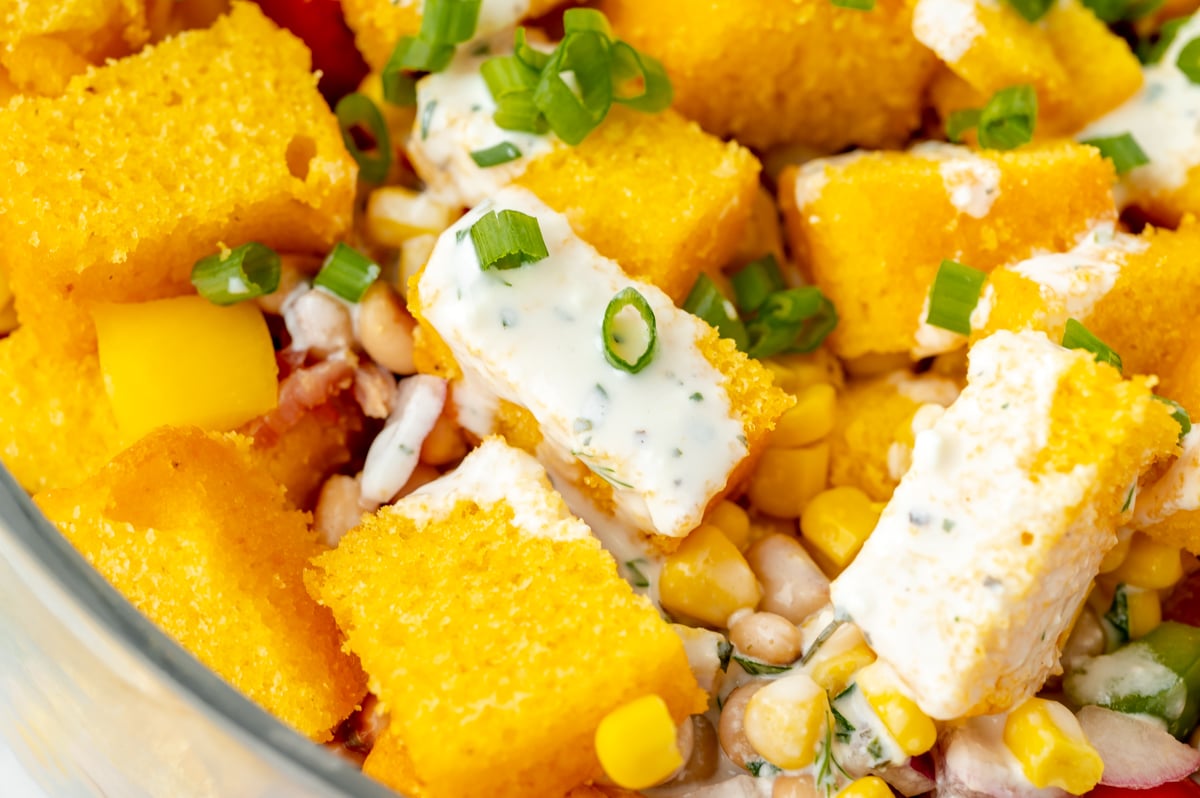 close up angled shot of cornbread cubes topped with dressing