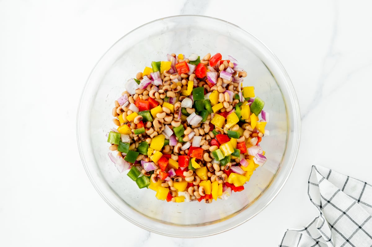 chopped veggies and black eyed peas tossed in bowl