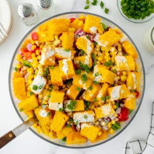 overhead shot of serving spoon in bowl of cornbread salad