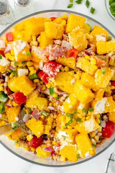 overhead shot of serving spoon in bowl of cornbread salad