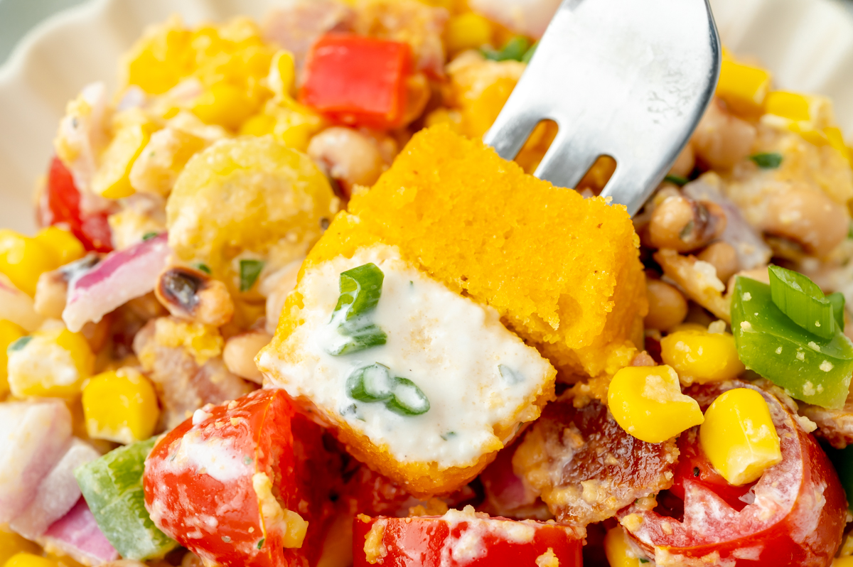 close up angled shot of fork full of cornbread salad