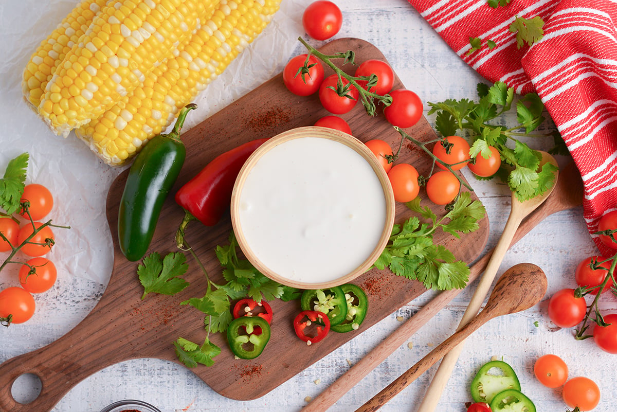 overhead shot of bowl of mexican sour cream on wooden board