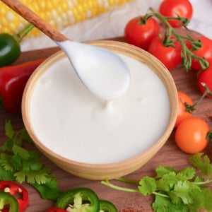 close up angled shot of spoon in bowl of crema mexicana