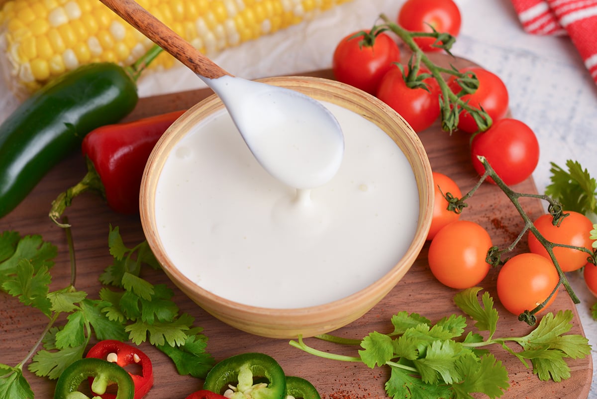 close up angled shot of spoon in bowl of crema mexicana