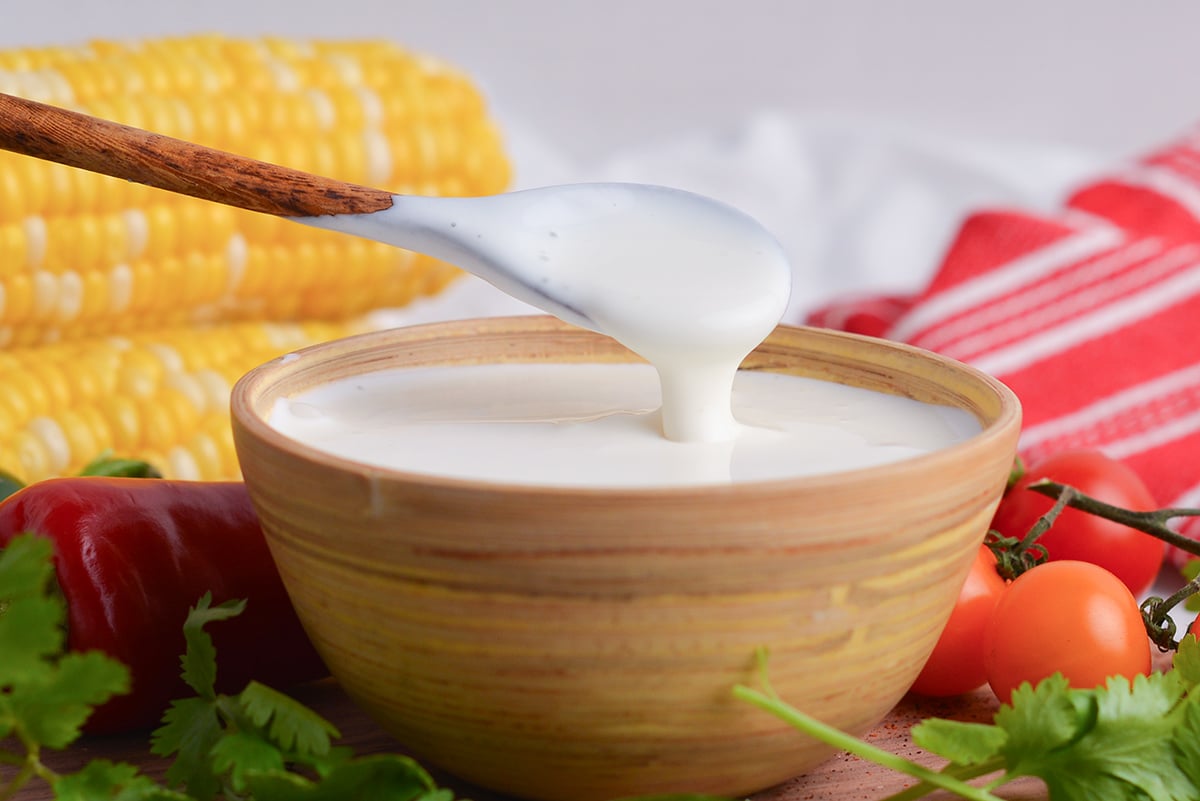 straight on shot of spoon in bowl of homemade mexican crema recipe