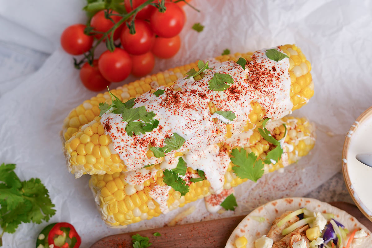 overhead shot of mexican street corn drizzled with mexican crema 
