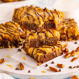 stack of chocolate caramel brownies with nuts and coconut caramel topping