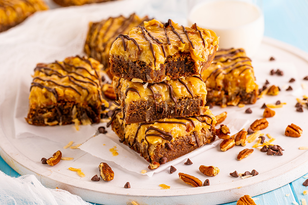 stack of chocolate caramel brownies with nuts and coconut caramel topping