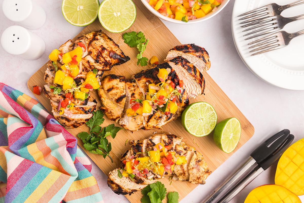 overhead shot of sliced grilled mango chicken on cutting board