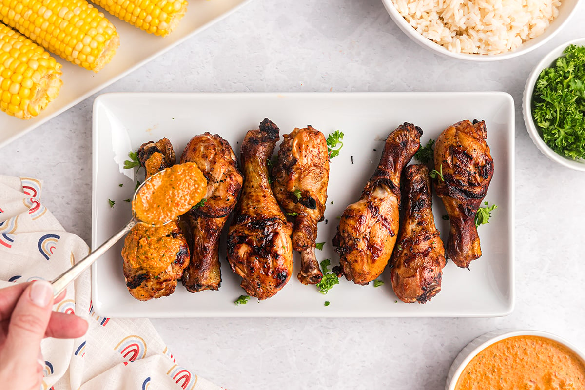 overhead shot of spoon adding peri peri sauce to chicken