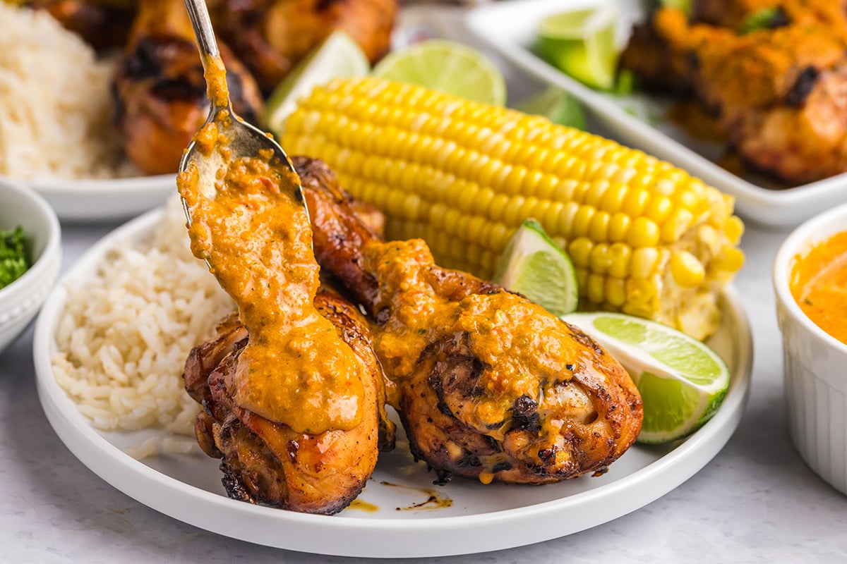 close up of plate of peri peri chicken with rice and corn