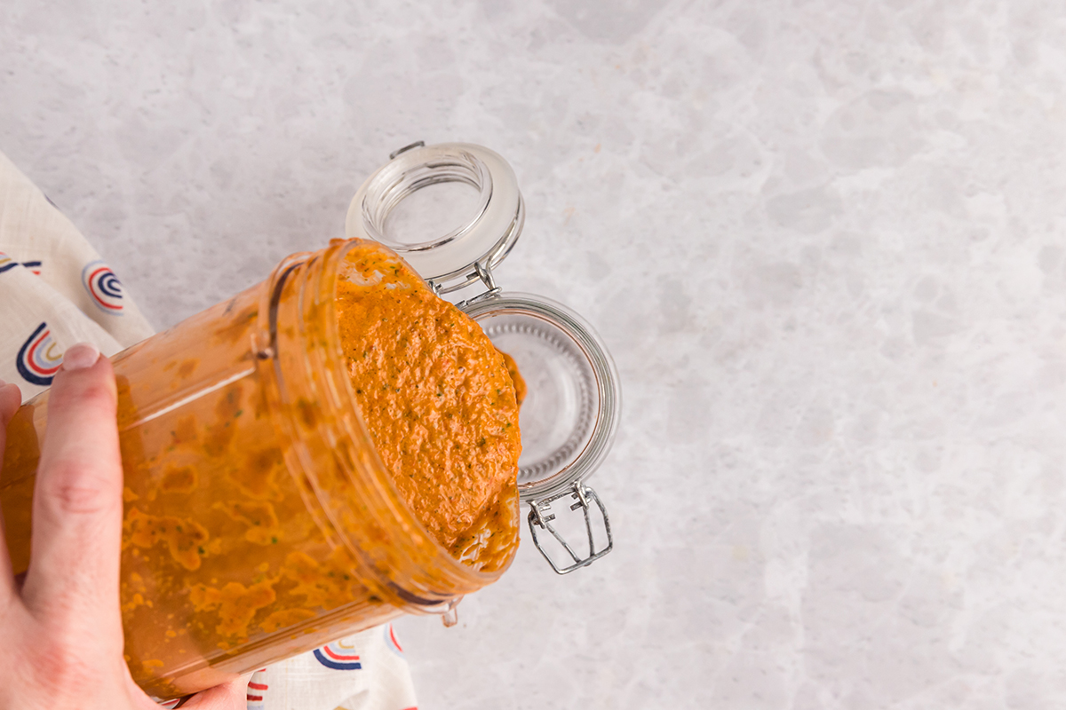 overhead shot of red sauce poured into jar