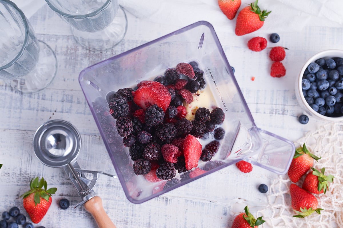 berries, milk and ice cream in blender