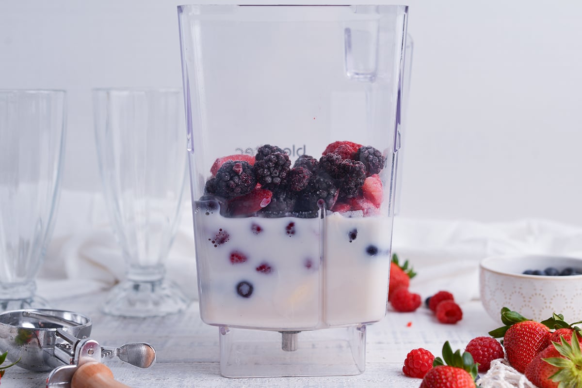 straight on shot of milk and berries in blender