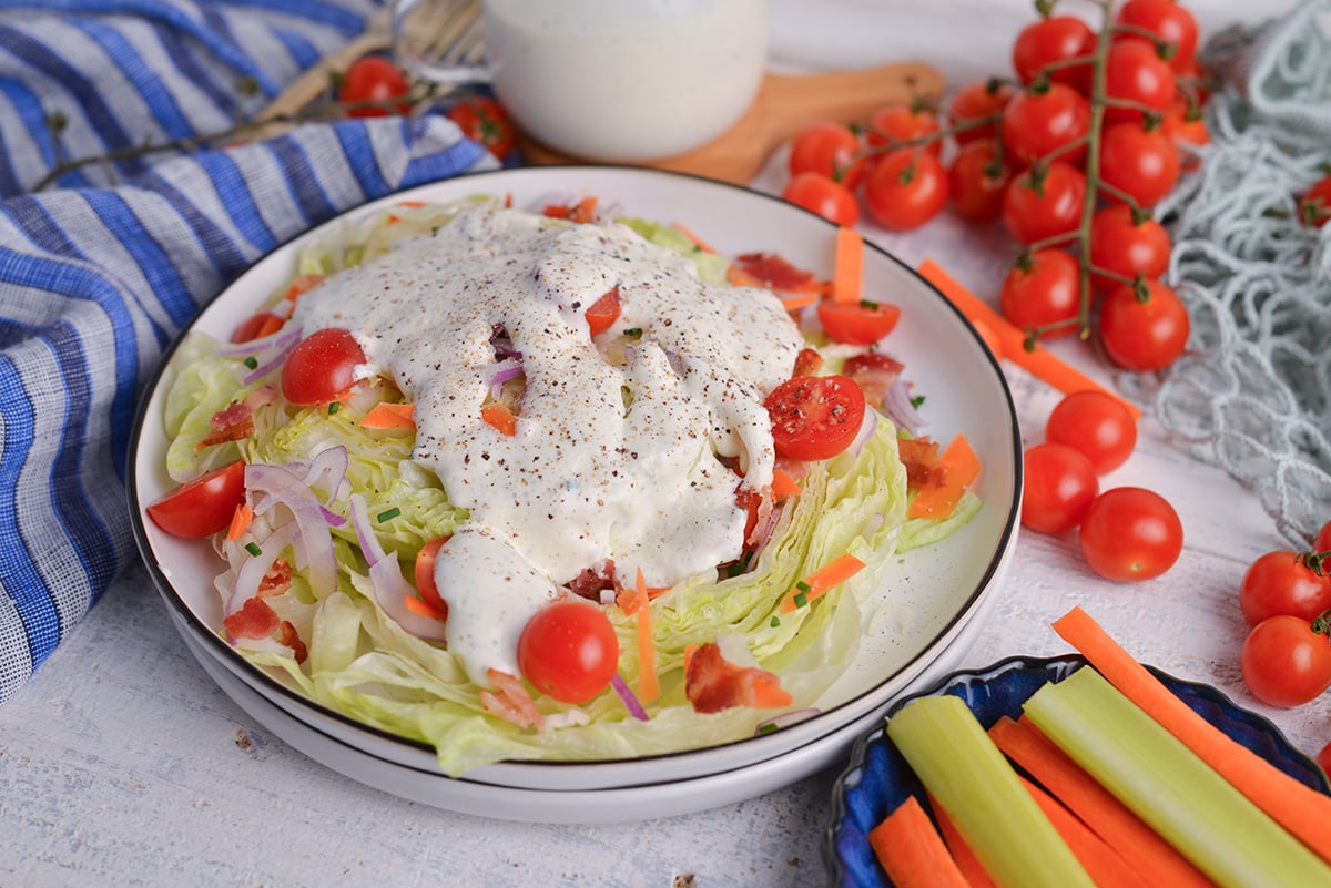 angled shot of salad topped with white creamy dressing