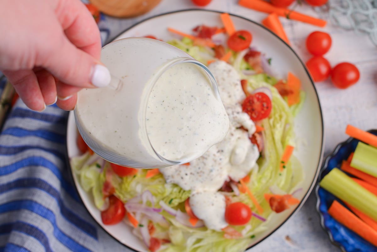 overhead shot of healthy ranch sauce pouring over salad