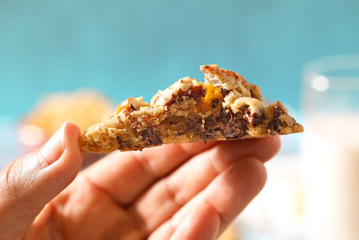 hand holding cross sectional view of a warm homemade cookie