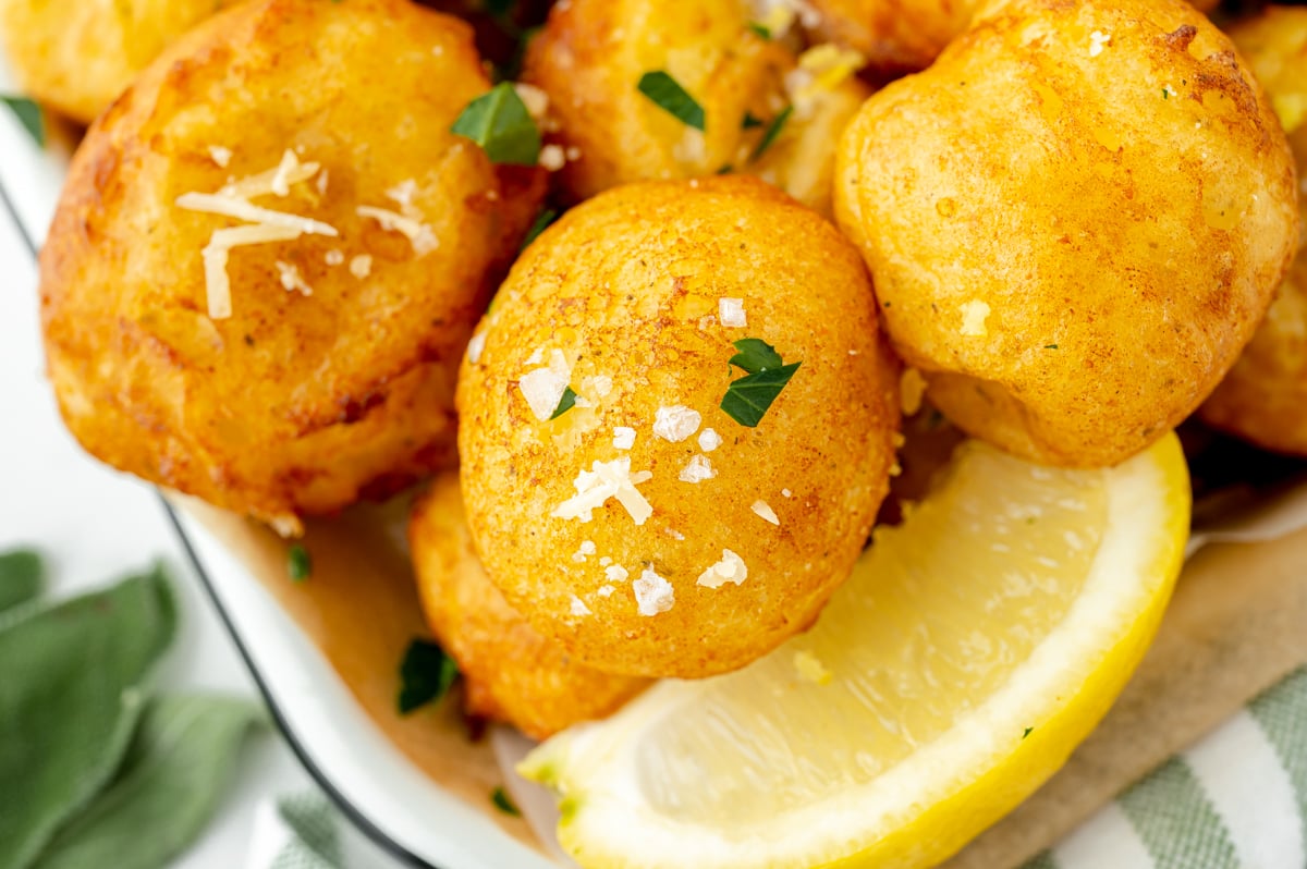 overhead shot of lemon ricotta fritters with lemon wedge