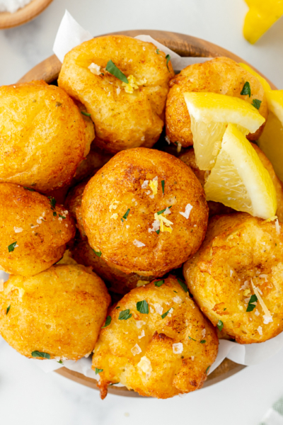 overhead shot of bowl of lemon ricotta fritters with lemons