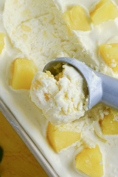 close up of scoop of homemade no churn ice cream with pineapple chunks