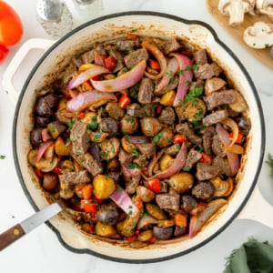 overhead shot of steak and potato skillet in pan with serving spoon