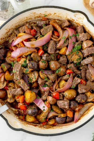 overhead shot of steak and potato skillet in pan with serving spoon