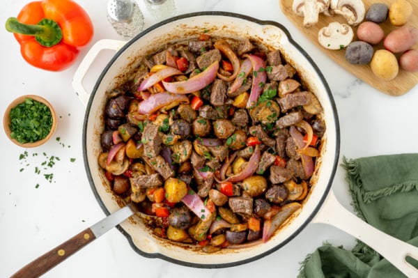 overhead shot of steak and potato skillet in pan with serving spoon