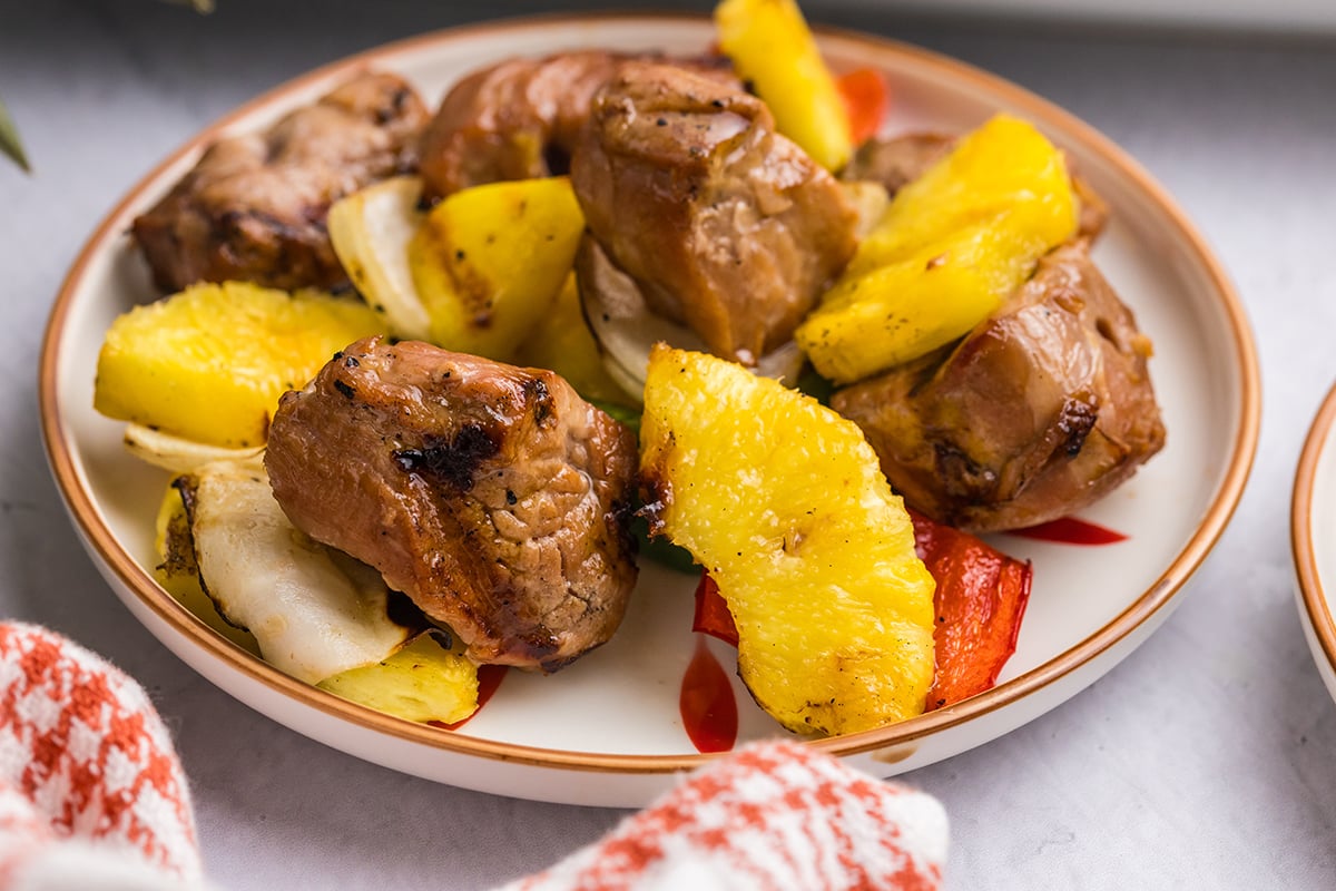 close up angled shot of teriyaki pork and pineapple on plate