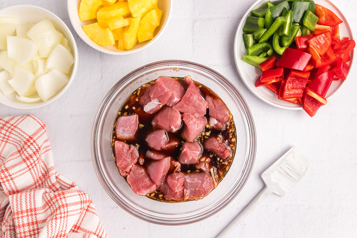 pork marinading in bowl of marinade