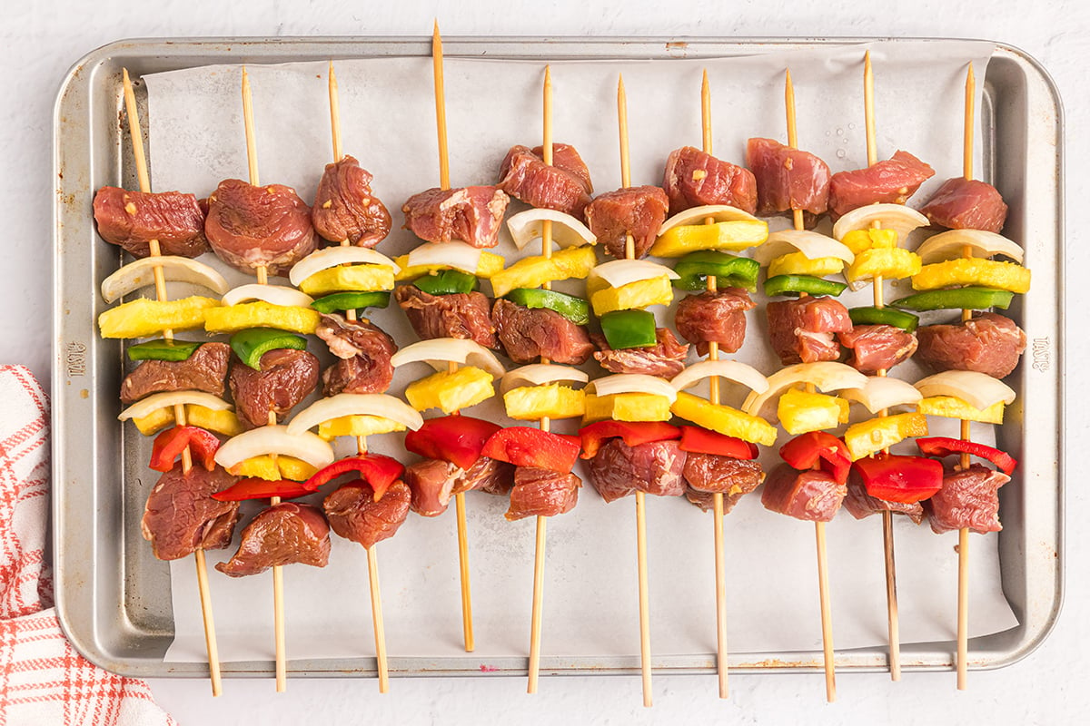 raw teriyaki pork kabobs on tray