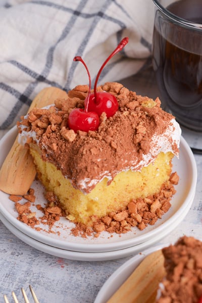 angled shot of slice of tiramisu poke cake on plate