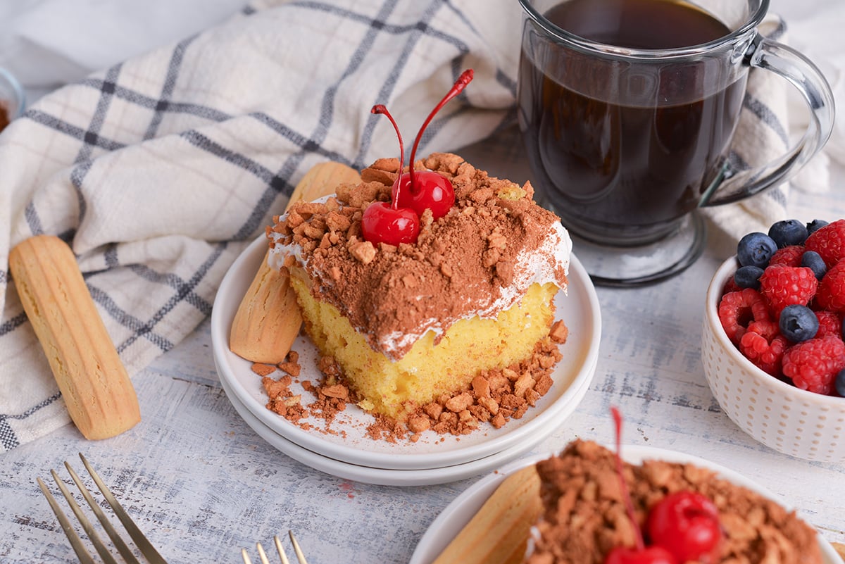 angled shot of slice of tiramisu poke cake on plate