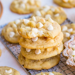 bite taken out of stack of white chocolate chip cookies