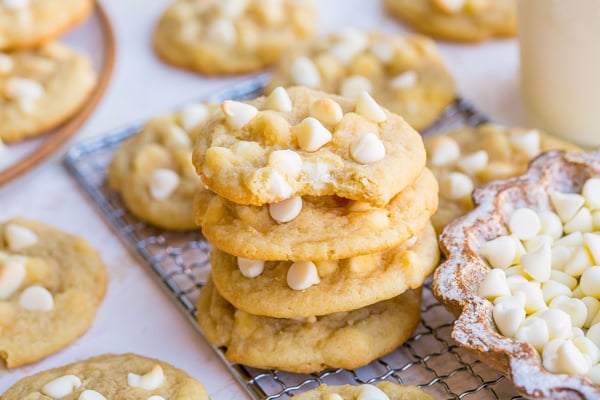bite taken out of stack of white chocolate chip cookies