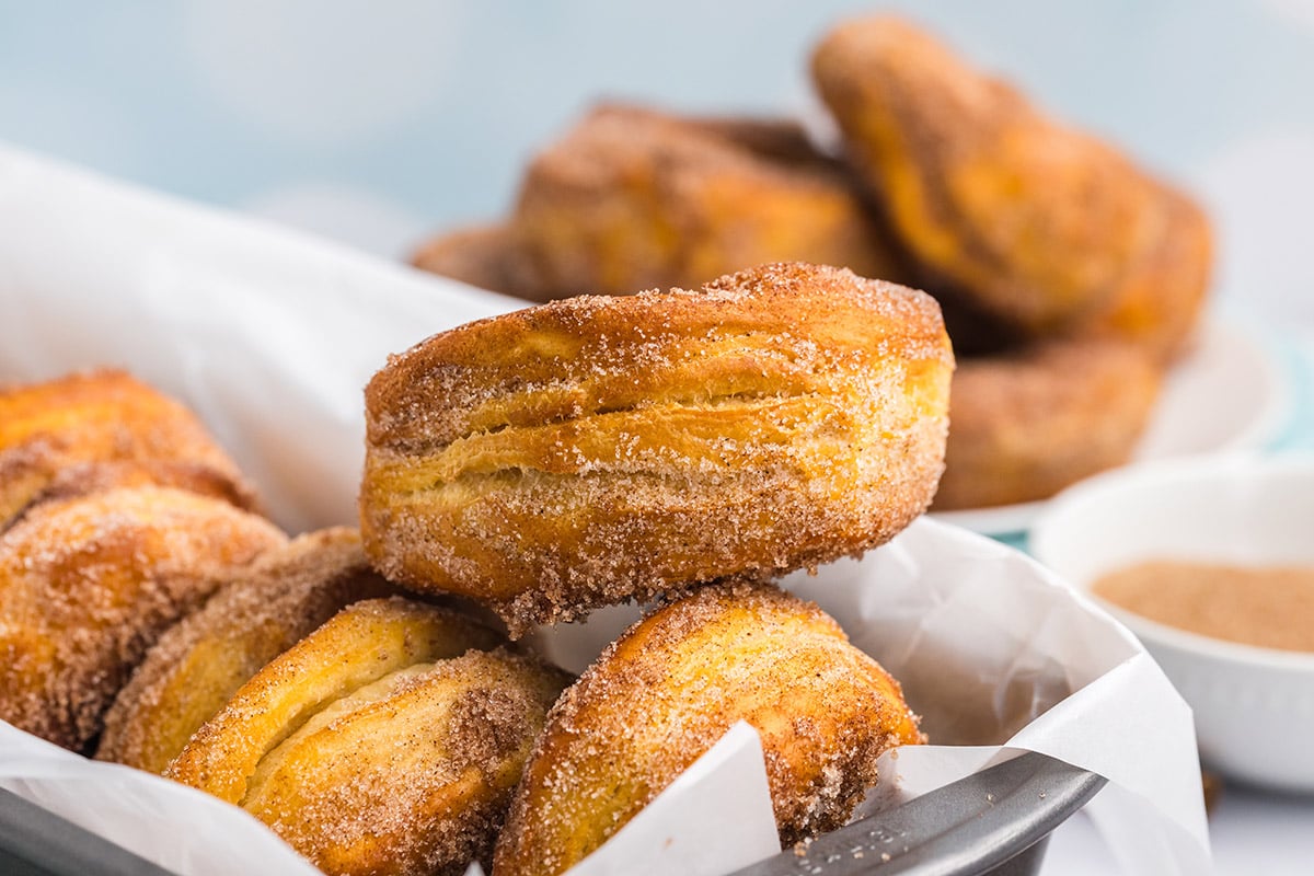 one cinnamon sugar donut balancing on others