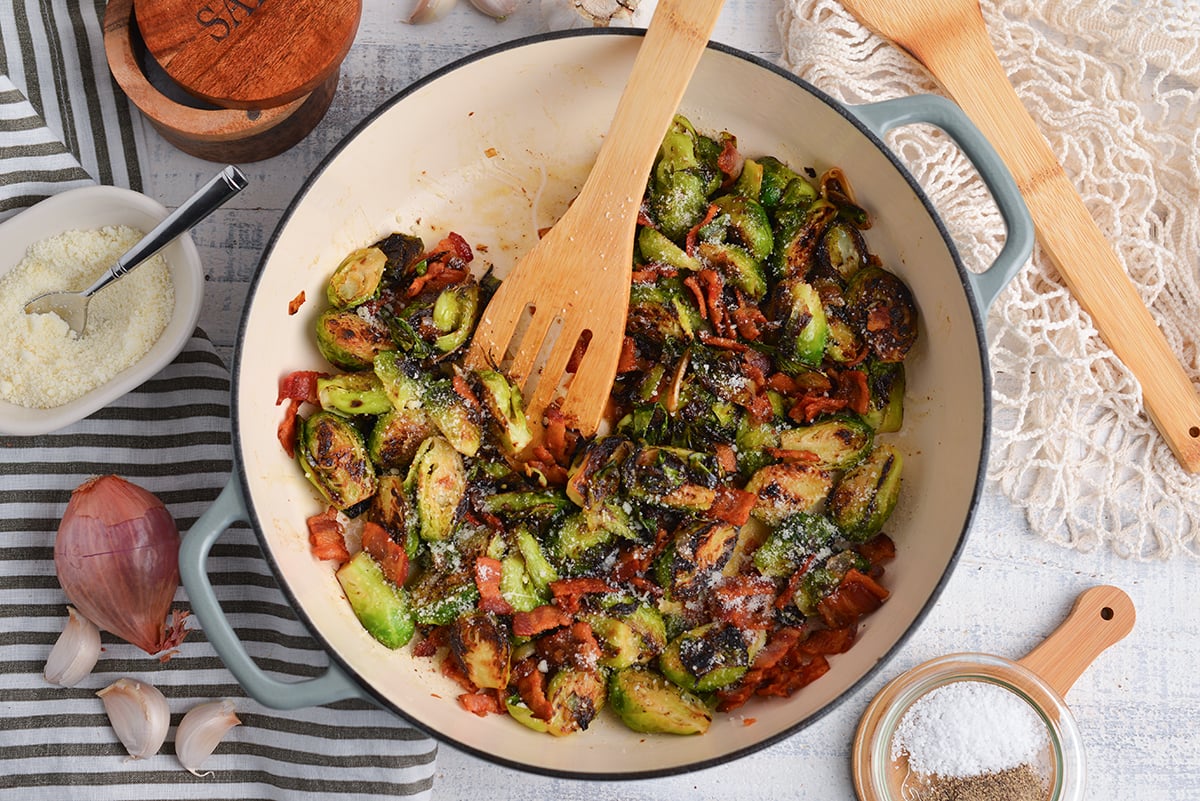 overhead shot of wooden spoon in pan of brussels sprouts with bacon