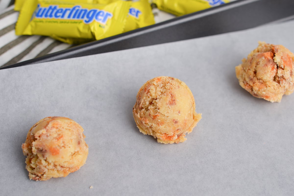 balls of butterfinger sugar cookie dough on cookie sheet