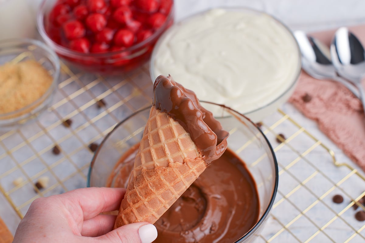 hand holding cone dipped in chocolate